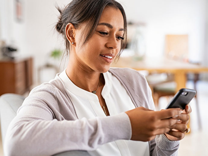 Young lady using her smartphone in her home