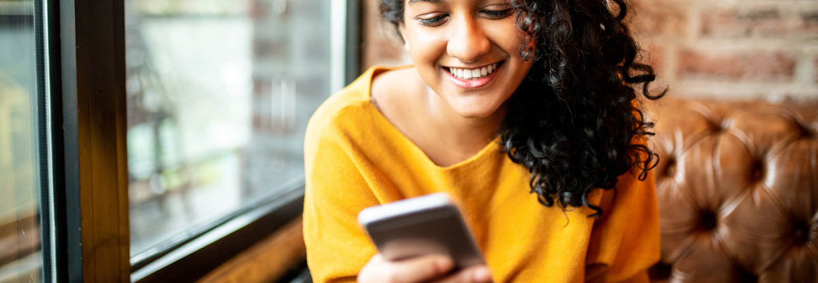 Young lady using her smartphone in a restaurant